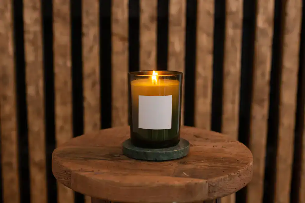 A collection of lit candles in elegant jars on a wooden table