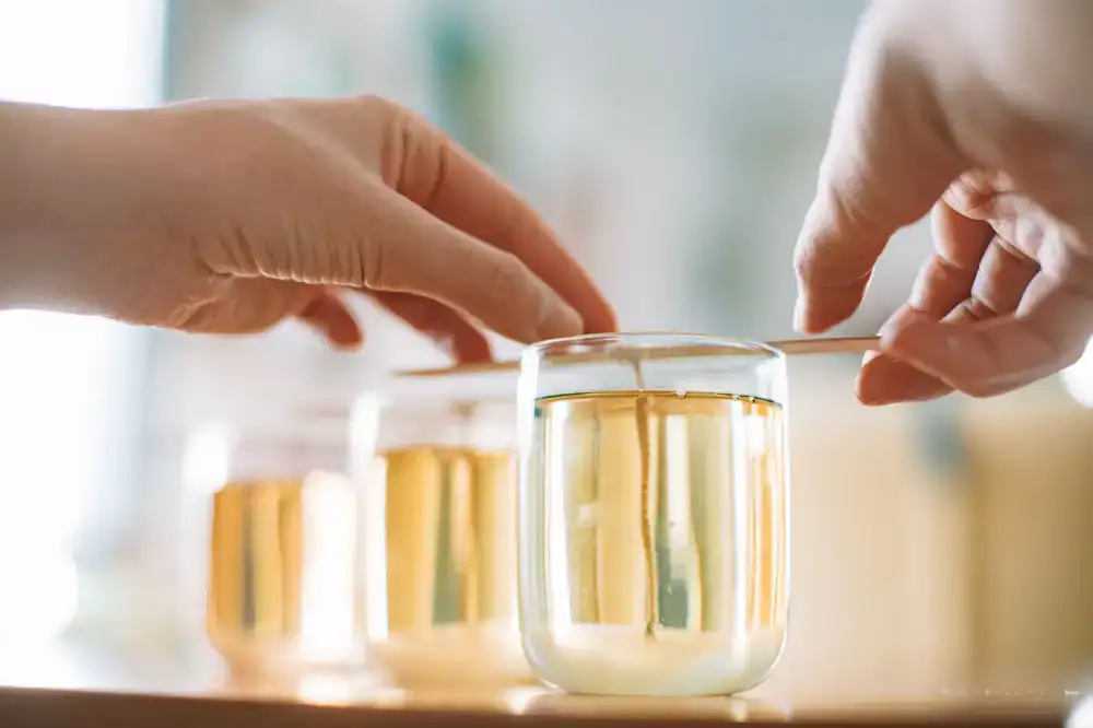 Close up of artisanal candle pouring process in warm ambient light